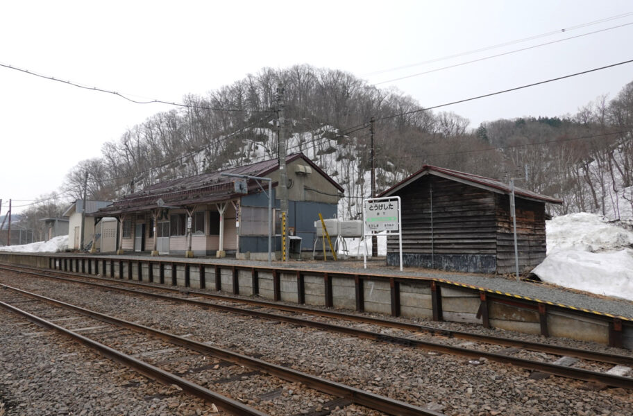 上り線ホームから峠下駅の駅舎と駅名標