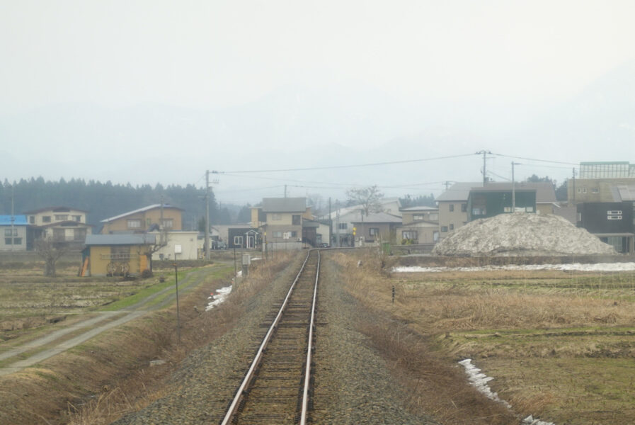 新庄駅に向けて右カーブを進もうとする快速・最上川