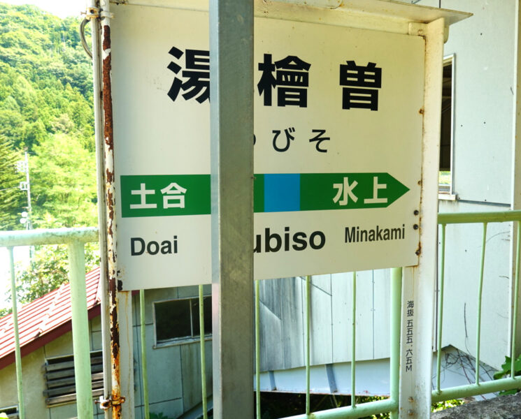 駅名標と湯檜曽駅（海抜555.65m)